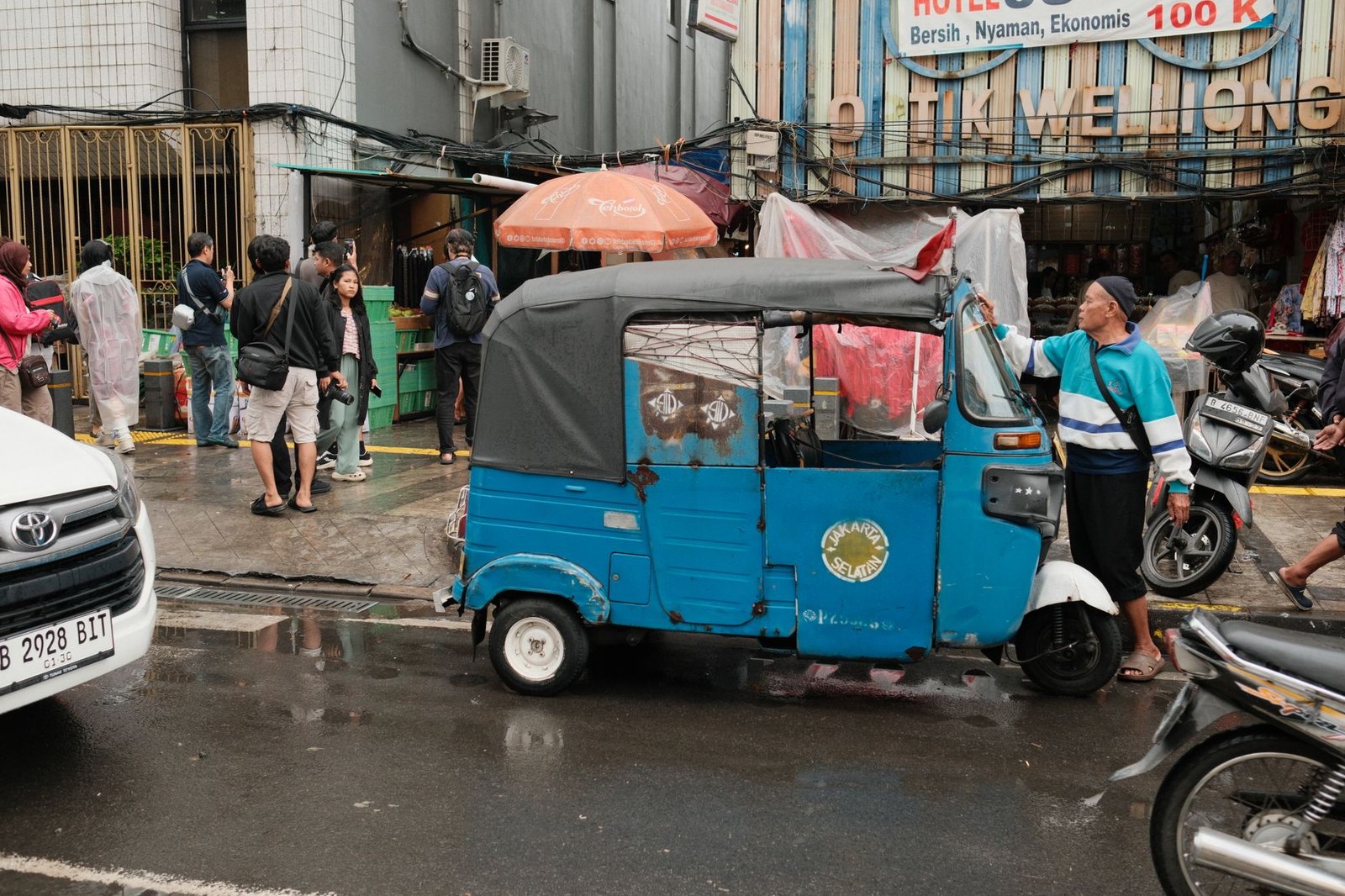 Gambar bengkel mobil Tangerang Selatan dengan teknisi yang sedang melakukan perawatan mobil.